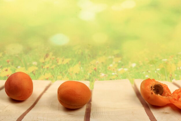 Rijpe abrikozen op een houten bord, groene zomerachtergrond, plaats voor tekst