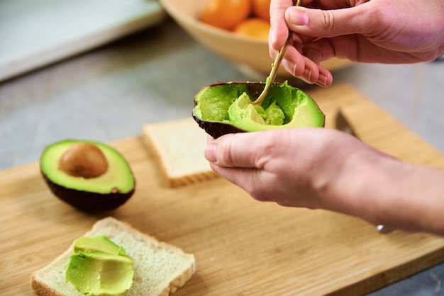 Rijpe avocado in vrouwenhanden gezond ontbijt