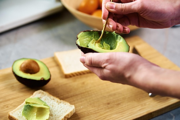 Rijpe avocado in vrouwenhanden gezond ontbijt