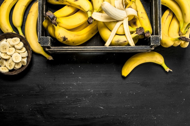 Rijpe bananen in een oude doos. Op het zwarte bord.