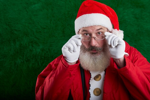 Rijpe bebaarde man met bril op zijn gezicht met kerstmuts