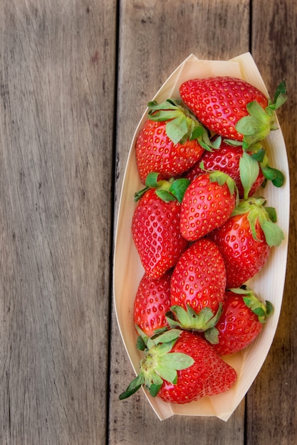 Rijpe biologische aardbeien in birchbark kom op donkere hout achtergrond