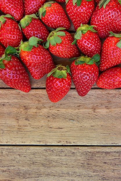 Rijpe biologische aardbeien verspreid over verweerde hout achtergrond Gezonde voeding