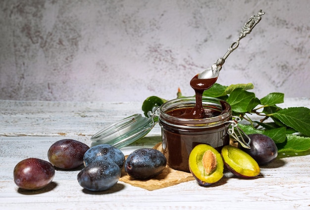 rijpe blauwe pruimen en pruimenjam op tafel