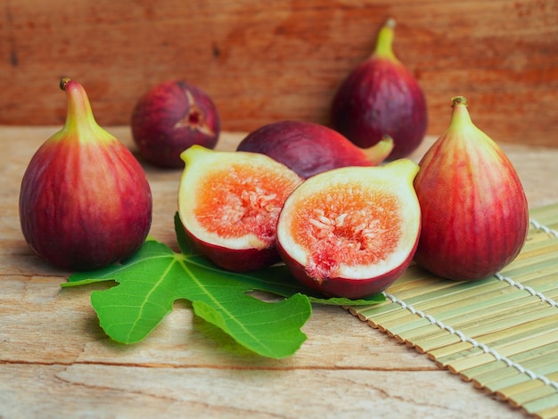 Rijpe bruine kalkoenvijg in tweeën gesneden en heel fruit op rustieke houten tafel