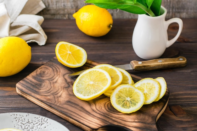 Rijpe citroenen snijden met een mes op een houten snijplank op tafel. Biologische voeding, bron van vitamines.