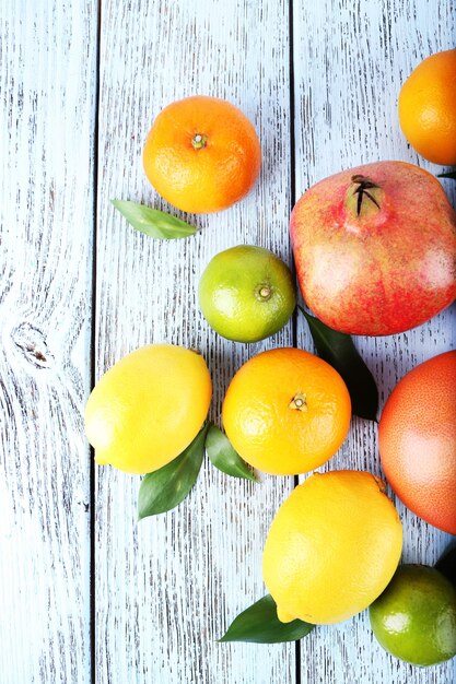 Rijpe citrus met groene bladeren op houten achtergrond