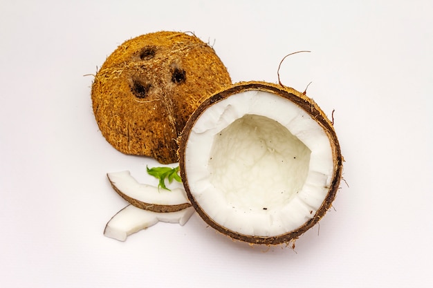 Rijpe die kokosnoot op twee half wordt geïsoleerd op witte achtergrond wordt gesneden
