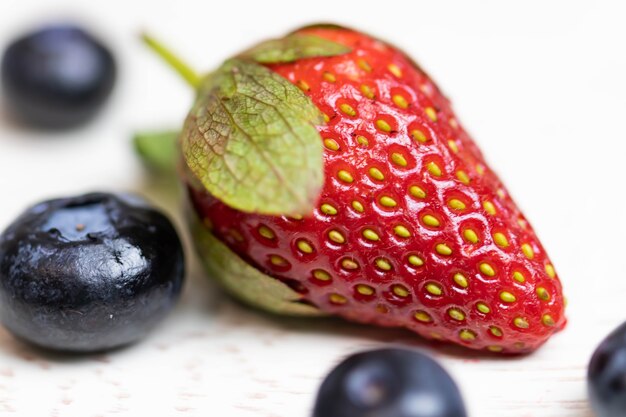 Rijpe en sappige aardbeien en bosbessen op een witte achtergrond. gezond eten.