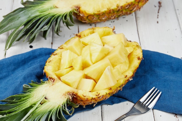 Rijpe en sappige ananas op een witte houten tafel ananas halve plakjes close-up