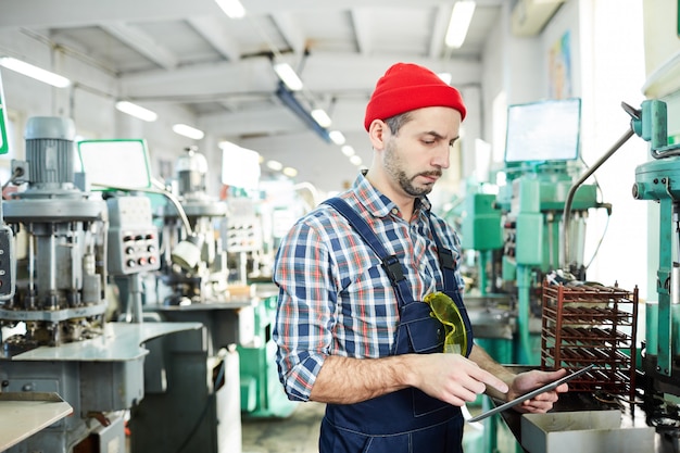 Rijpe Fabrieksarbeider die Tablet door Machines gebruiken