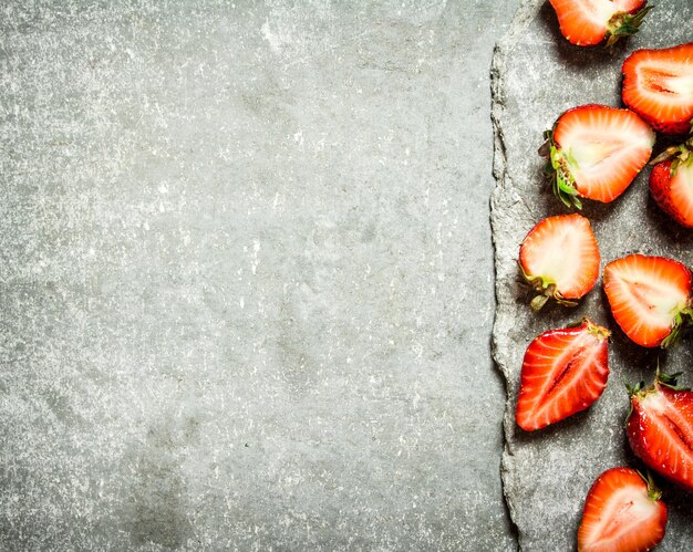 Rijpe gehalveerde aardbeien op beton