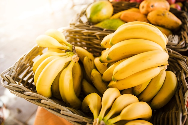 Foto rijpe gele bananen in rieten mand bij fruitmarktopslag