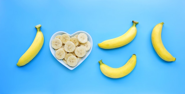 Rijpe gele bananen op blauwe achtergrond.