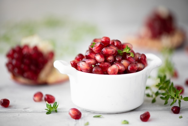 Rijpe gepelde granaatappelpitjes in een witte kom