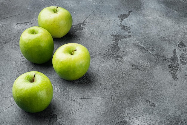 Rijpe groene appels op grijze stenen tafelachtergrond met kopieerruimte voor tekst