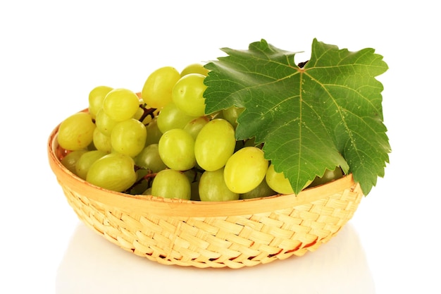 Rijpe heerlijke druiven in rieten mand geïsoleerd op wit