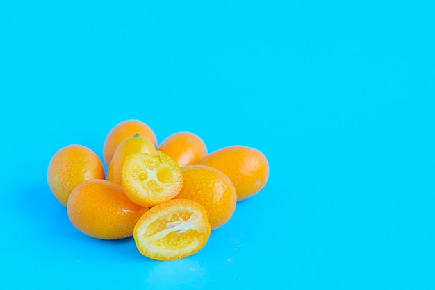 Rijpe kumquat op een blauwe achtergrond, exotische citrusvruchten