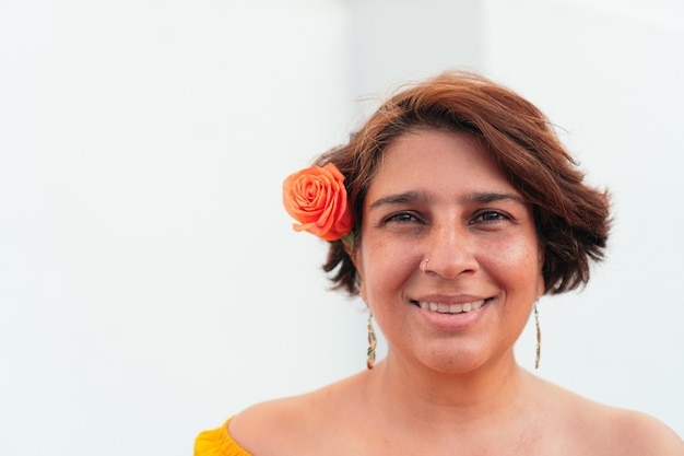 Rijpe Latijnse vrouw met oranje bloemen