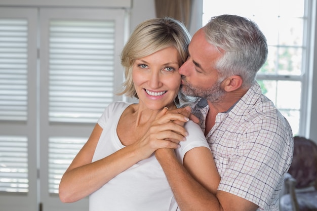 Rijpe man die een gelukkige vrouw kust