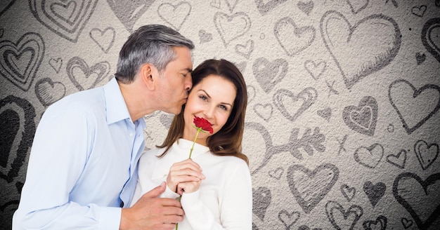 Rijpe man kust terwijl hij een rode roos geeft aan vrouw