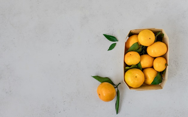 Rijpe mandarijnen, citrusvruchten met bladeren in een mand.