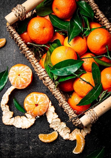 Foto rijpe mandarijnen met bladeren in een mand