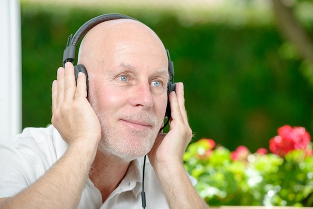 Foto rijpe mens die aan muziek luistert