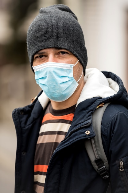 Foto rijpe mens die hygiënisch masker draagt om virus te verhinderen. milieu-concept