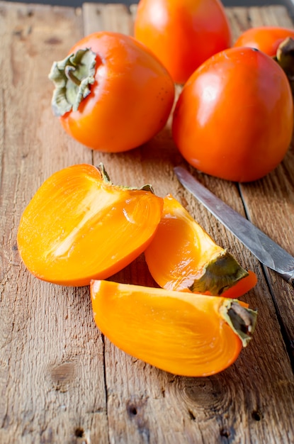 Rijpe oranje dadelpruimen op een oude houten lijst