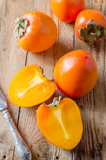 Rijpe oranje dadelpruimen op een oude houten lijst