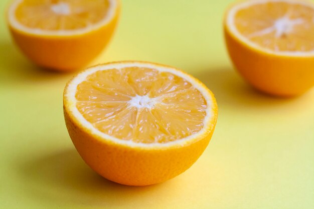 Rijpe oranje helften op een gele tafel