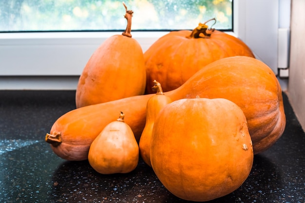 Rijpe oranje pompoenen op de vensterbank Herfstoogst van groenten