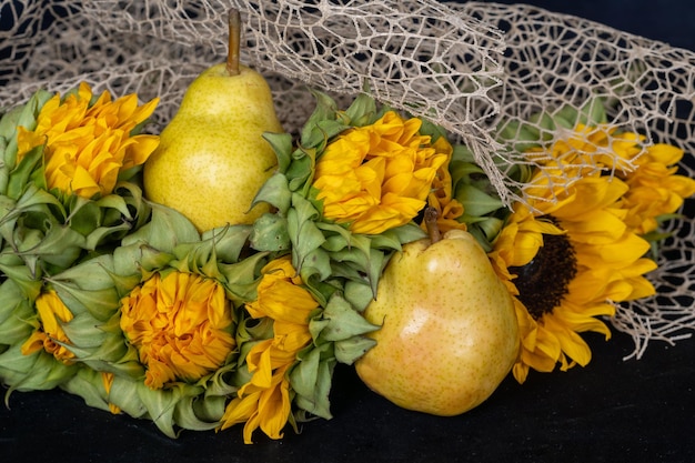 Foto rijpe peren en bos gele zonnebloemen herfstboeket