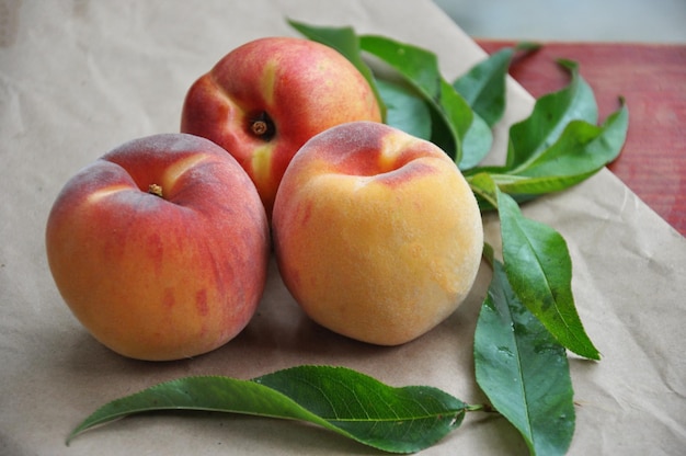 Rijpe perziken met bladeren Vijgenperzik Nectarine Saturnus Perziken platte perzik