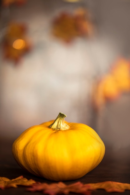 Rijpe pompoen en herfstbladeren op houten tafel op bruine achtergrond met kopie ruimte decoratieve c