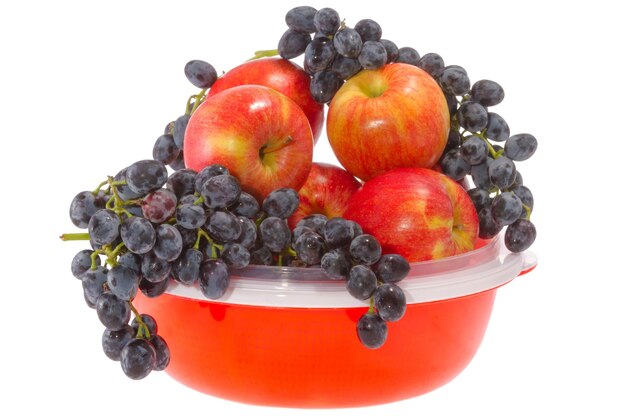 Rijpe rode appels en druiven op een bord