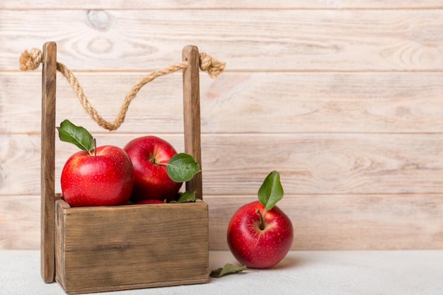 Rijpe rode appels in houten kist op een witte houten achtergrond