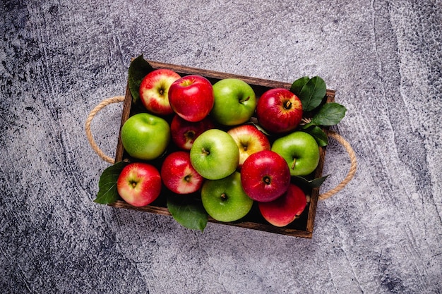 Rijpe rode en groene appels in houten kist