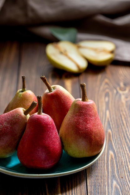 Rijpe rode peren op een blauw bord op een houten tafel close-up