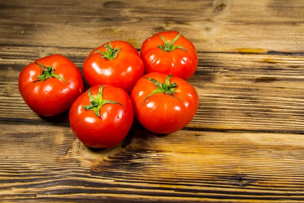 Rijpe rode tomaten op houten tafel