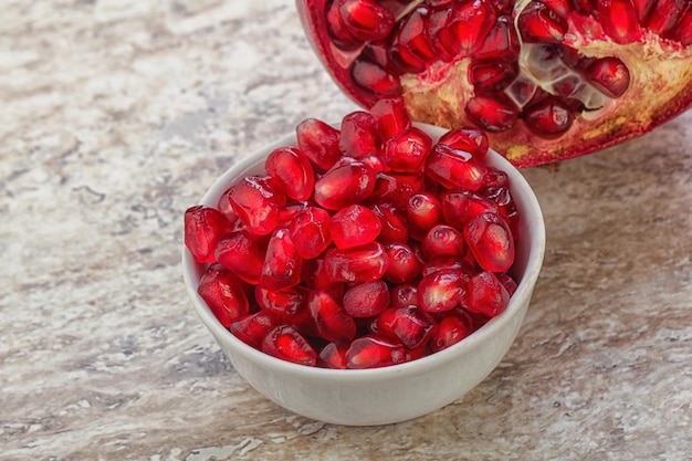 Rijpe rode zoete granaatappelpitjes in de kom