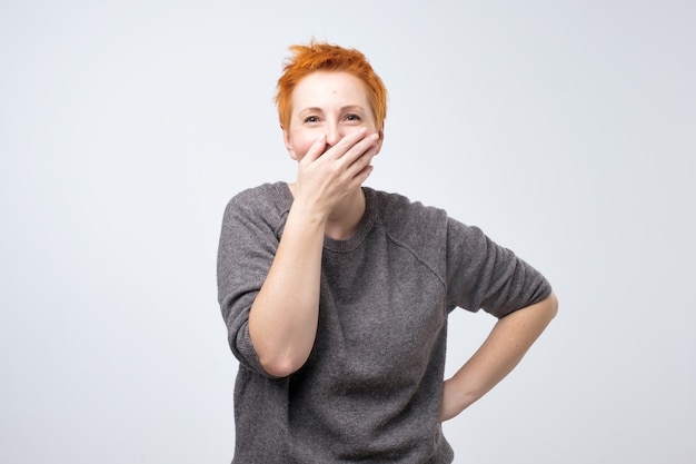 Rijpe roodharige vrouw in een grijze blouse