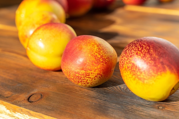 Rijpe sappige nectarines op een houten ondergrond. oogst van fruit. detailopname