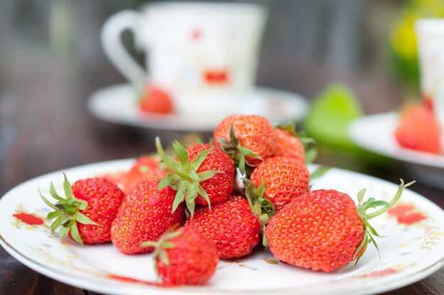 Rijpe smakelijke aardbeien verspreid over het witte bord