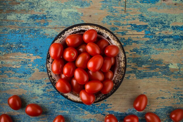 Rijpe tomaten in een metalen plaat op een houten tafel