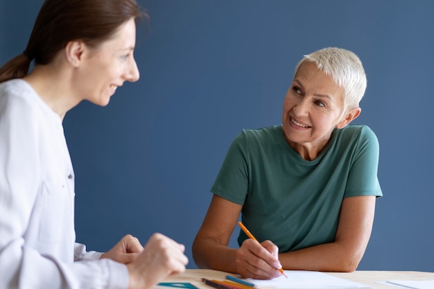 Foto rijpe vrouw die een ergotherapiesessie heeft met een psycholoog