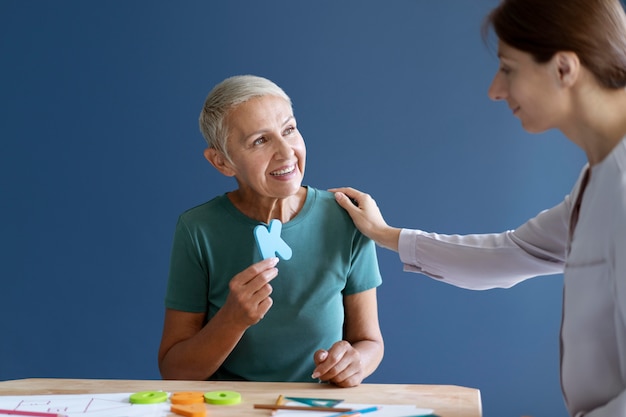 Rijpe vrouw doet een ergotherapiesessie met een psycholoog