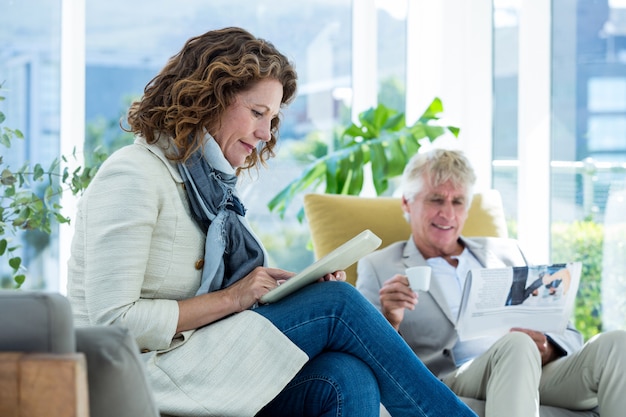 Rijpe vrouw door de mens die digitale tablet gebruiken