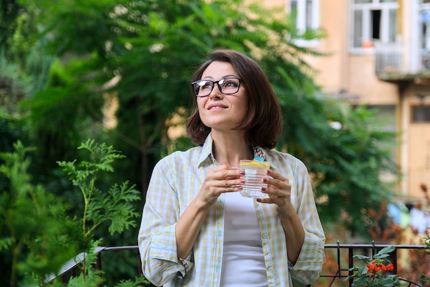 Rijpe vrouw drinkwater met citroen. Natuurlijke antioxidant, dieetdrank, gezondheid, eerste ochtenddrank